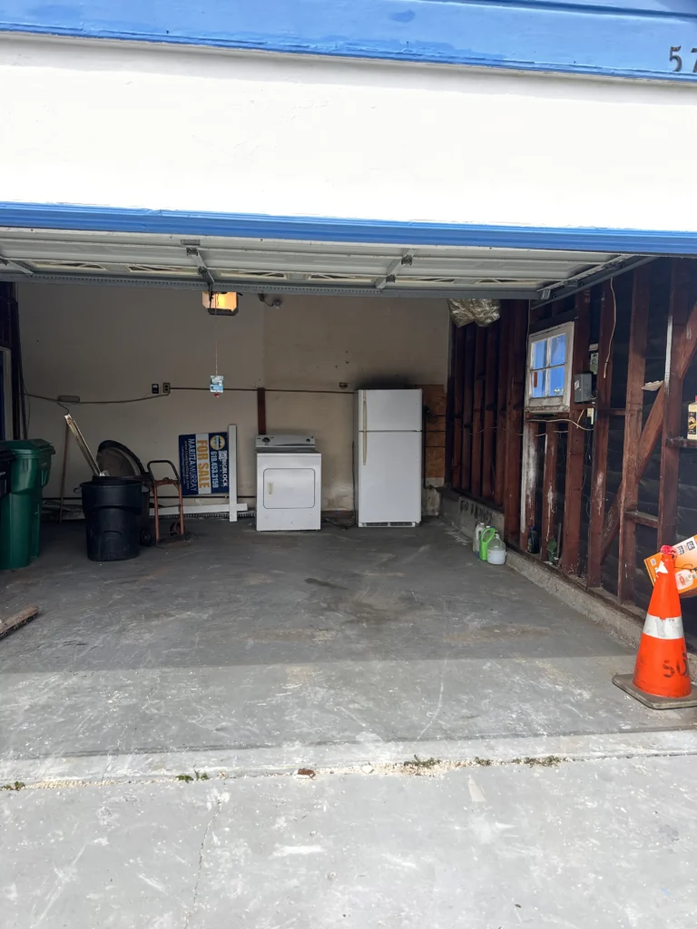 Empty garage with appliances and trash