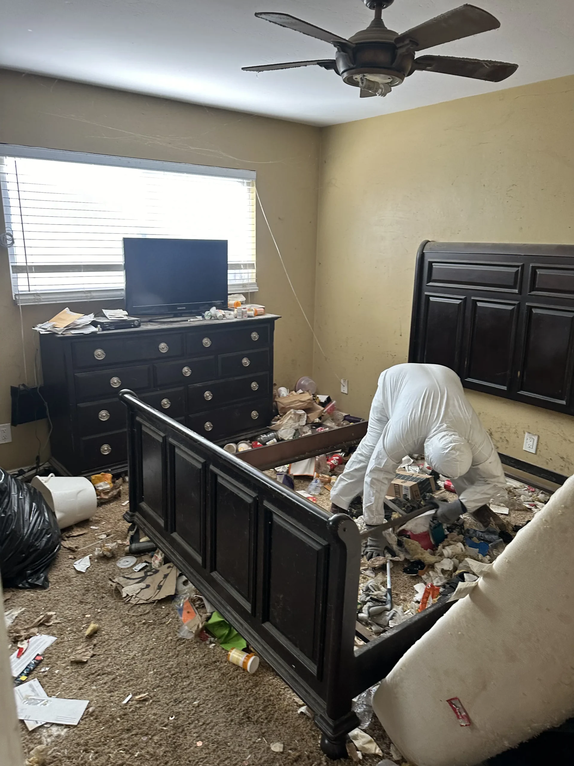 Messy room with person cleaning debris